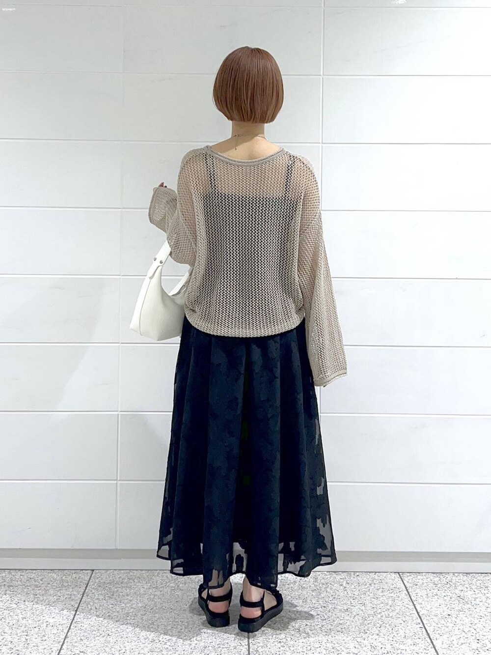 ブラック系のサンダル、ベージュ系のニット/セーター、ブラック系のキャミソールを着用したレディースの春コーディネートの3枚目の写真