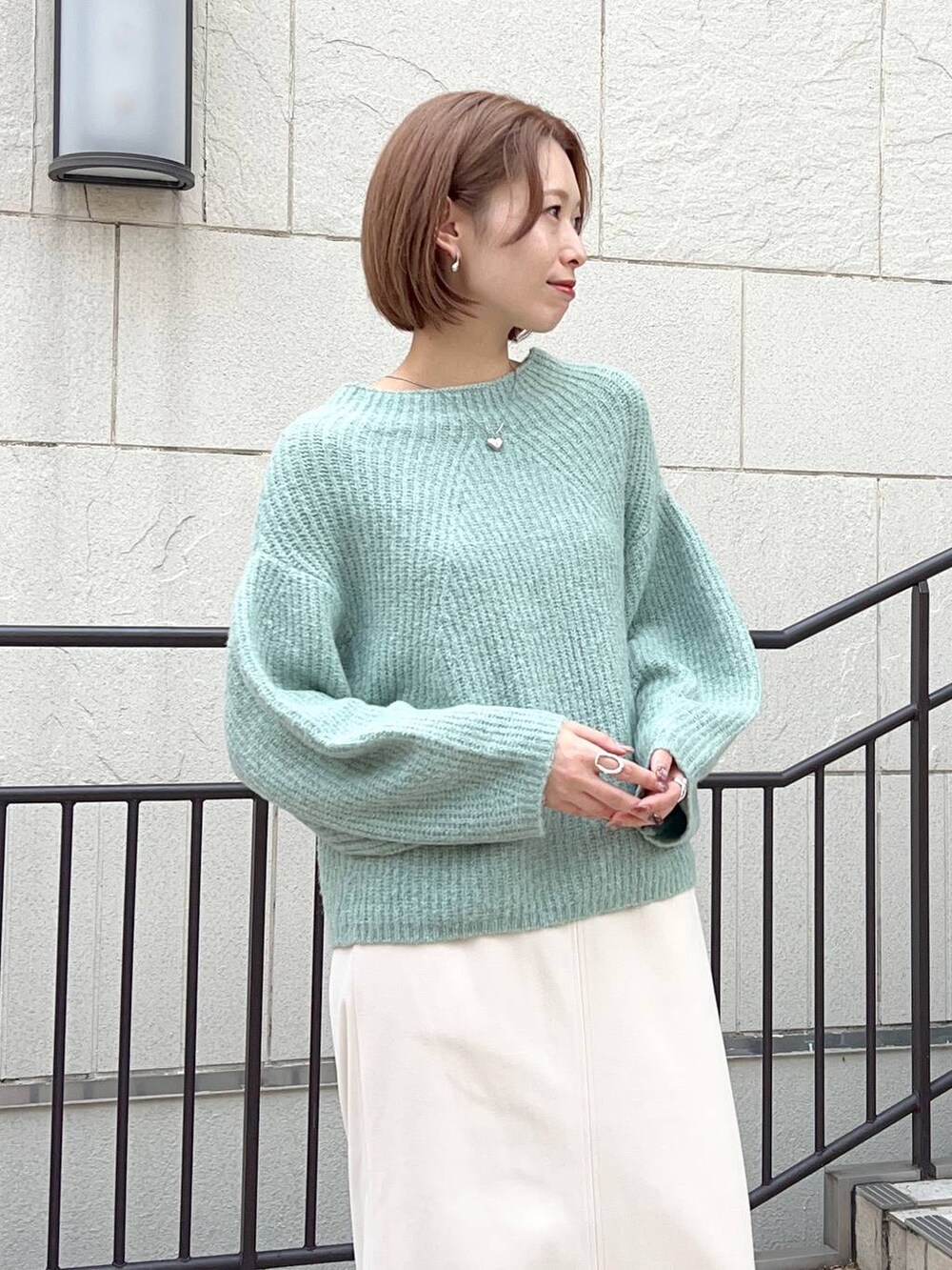 グレー系のノーカラーコート、ブラック系のショルダーバッグ、ブラック系のブーツを着用したレディースの秋コーディネートの7枚目の写真