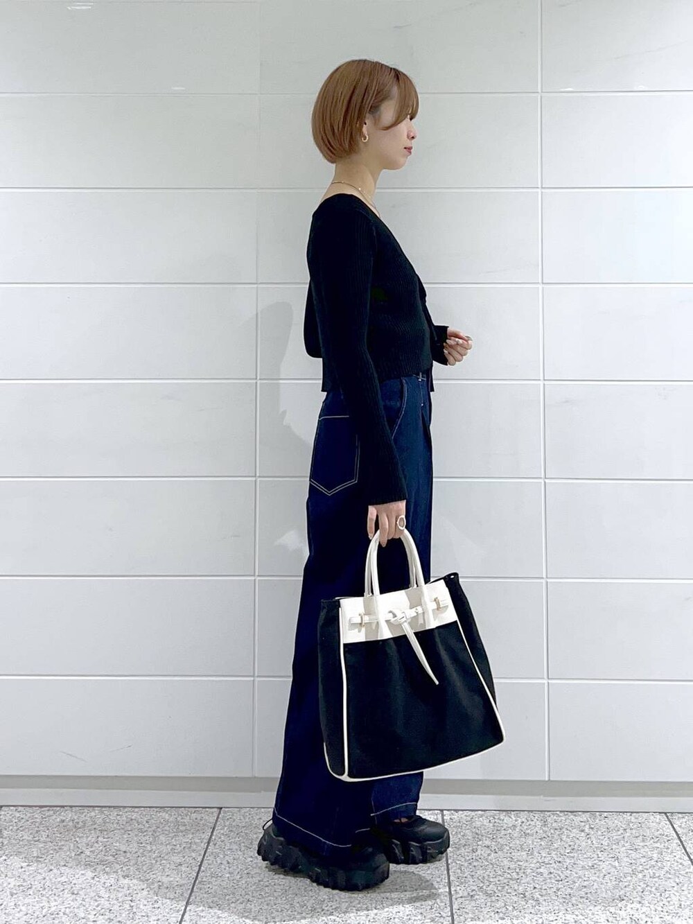 ブラック系のトートバッグ、グリーン系のマウンテンパーカー、ブラック系のバレエシューズを着用したレディースの春コーディネートの5枚目の写真