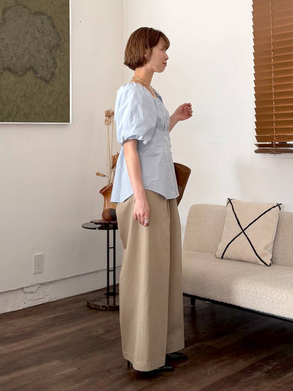 ブラウン系のトートバッグ、ブラック系のサンダル、ベージュ系のチノパンツを着用したレディースの春コーディネートの2枚目の写真