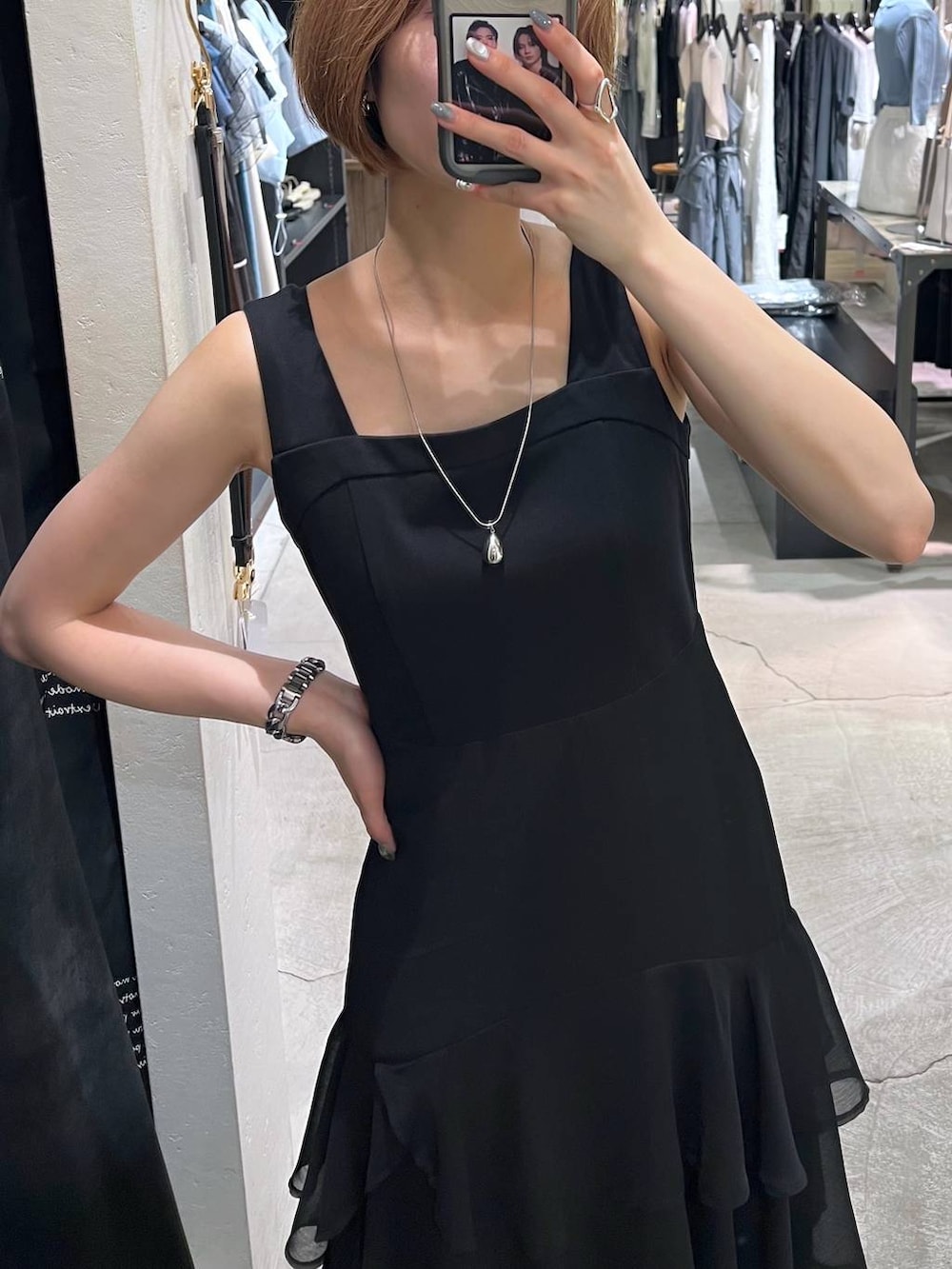 ベージュ系のテーラードジャケット、ブラック系のパンプス、ブラック系のワンピースを着用したレディースの夏コーディネートの3枚目の写真