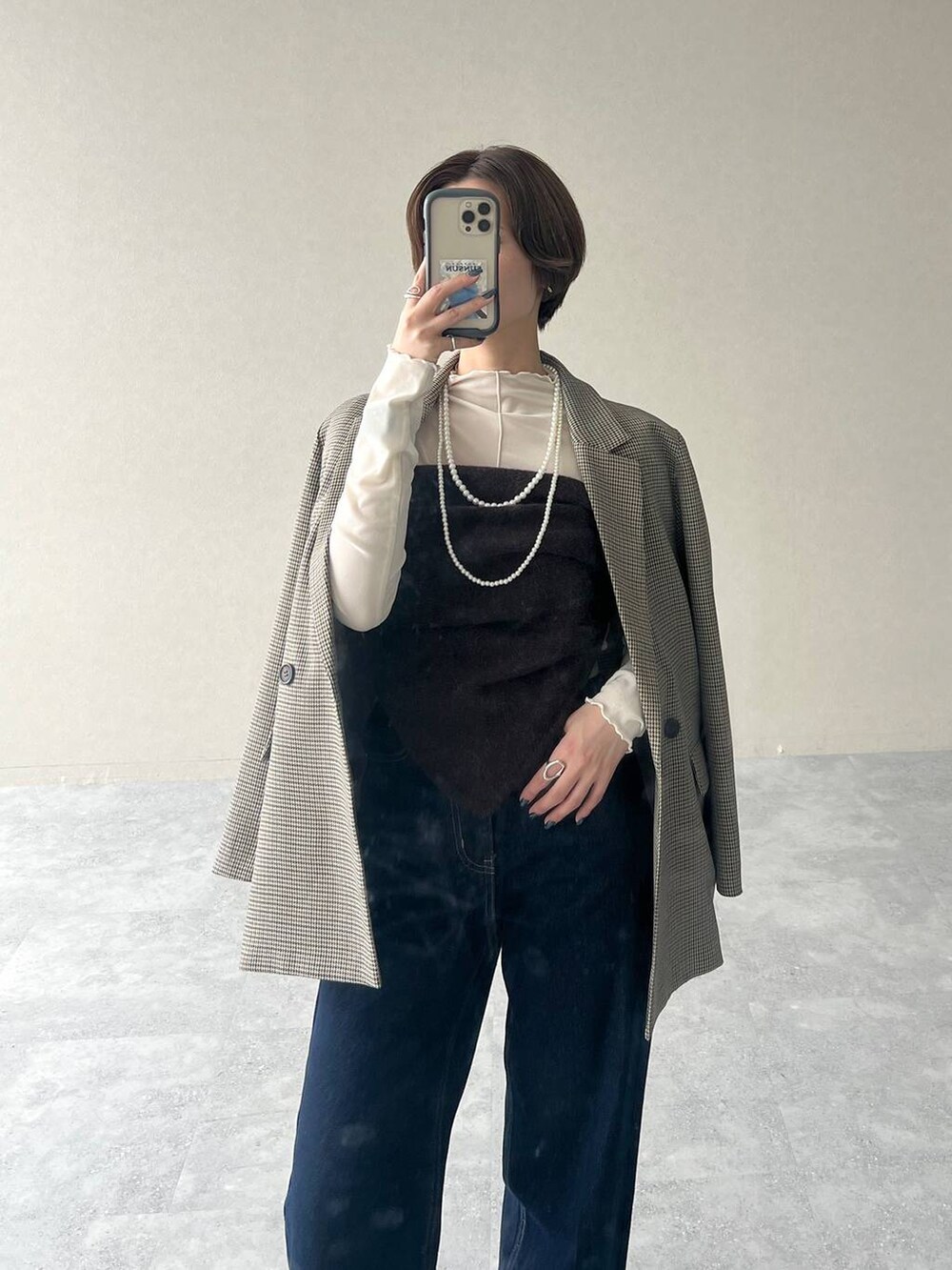 ベージュ系のテーラードジャケット、ブルー系のデニムパンツ、ブラック系のローファーを着用したレディースの秋コーディネートの4枚目の写真