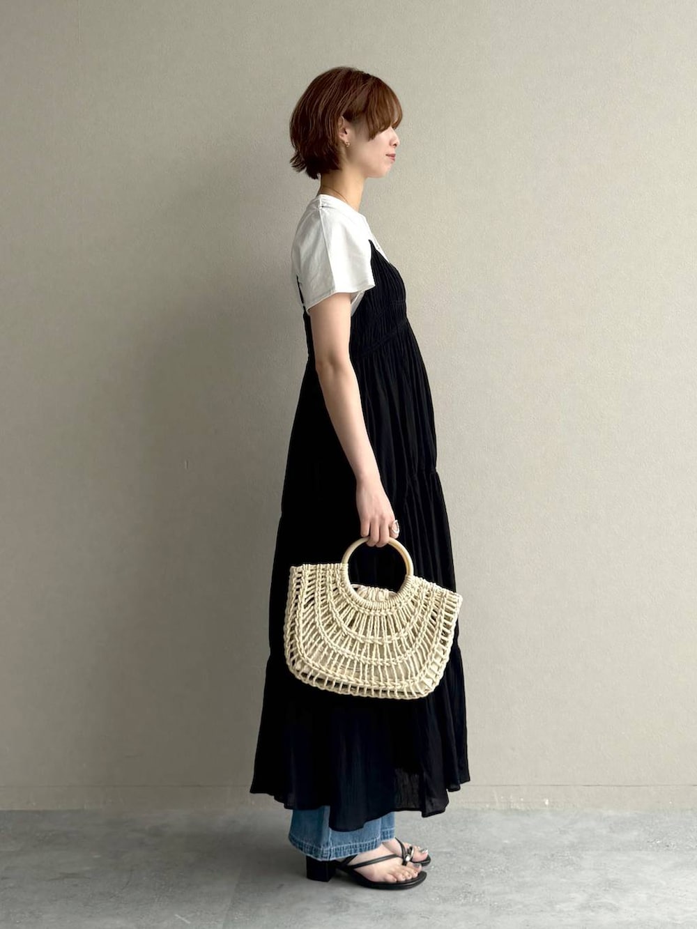 ブルー系のデニムパンツ、ホワイト系のTシャツ/カットソー、ブラック系のワンピースを着用したレディースの夏コーディネートの2枚目の写真