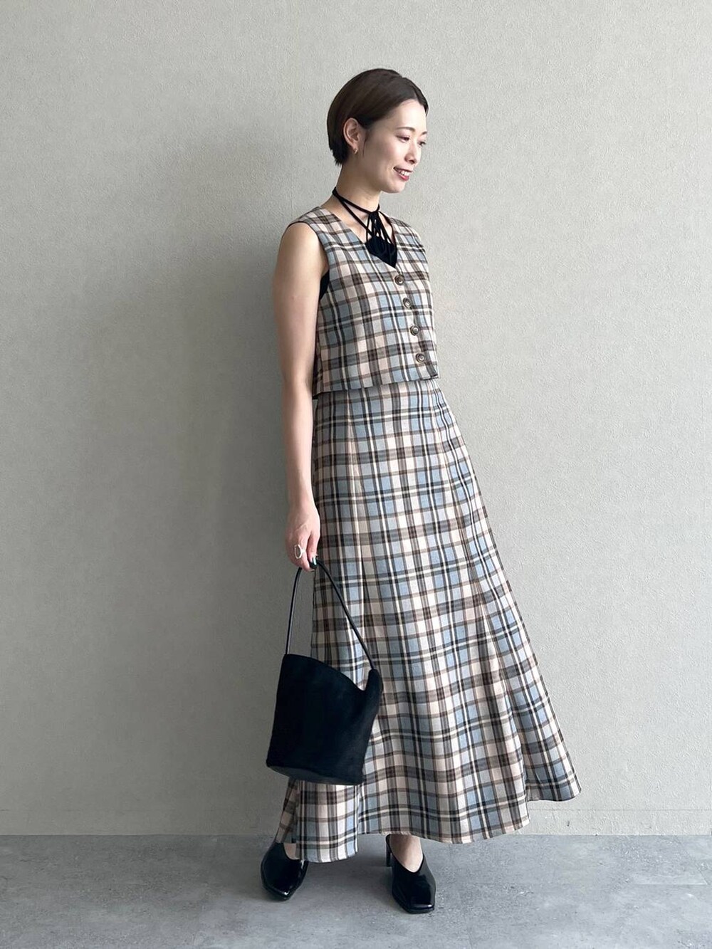 ブラック系のスリッポン、ブラック系のキャミソール、ブラック系のハンドバッグを着用したレディースの秋コーディネートの2枚目の写真