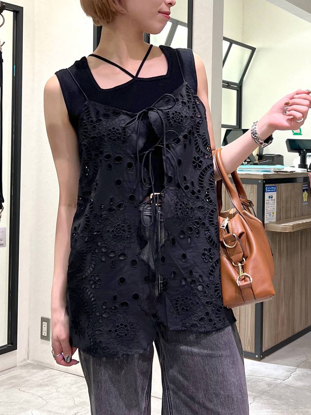 ブラック系のデニムパンツ、ブラック系のタンクトップ、ブラック系のサンダルを着用したレディースの夏コーディネートの4枚目の写真