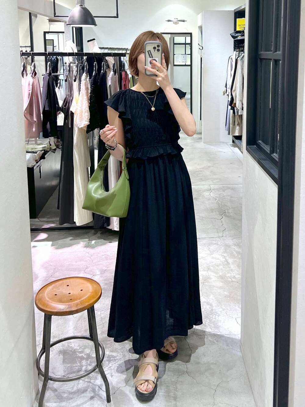 ベージュ系のサンダル、グリーン系のショルダーバッグ、ブラック系のワンピースを着用したレディースの夏コーディネートの5枚目の写真