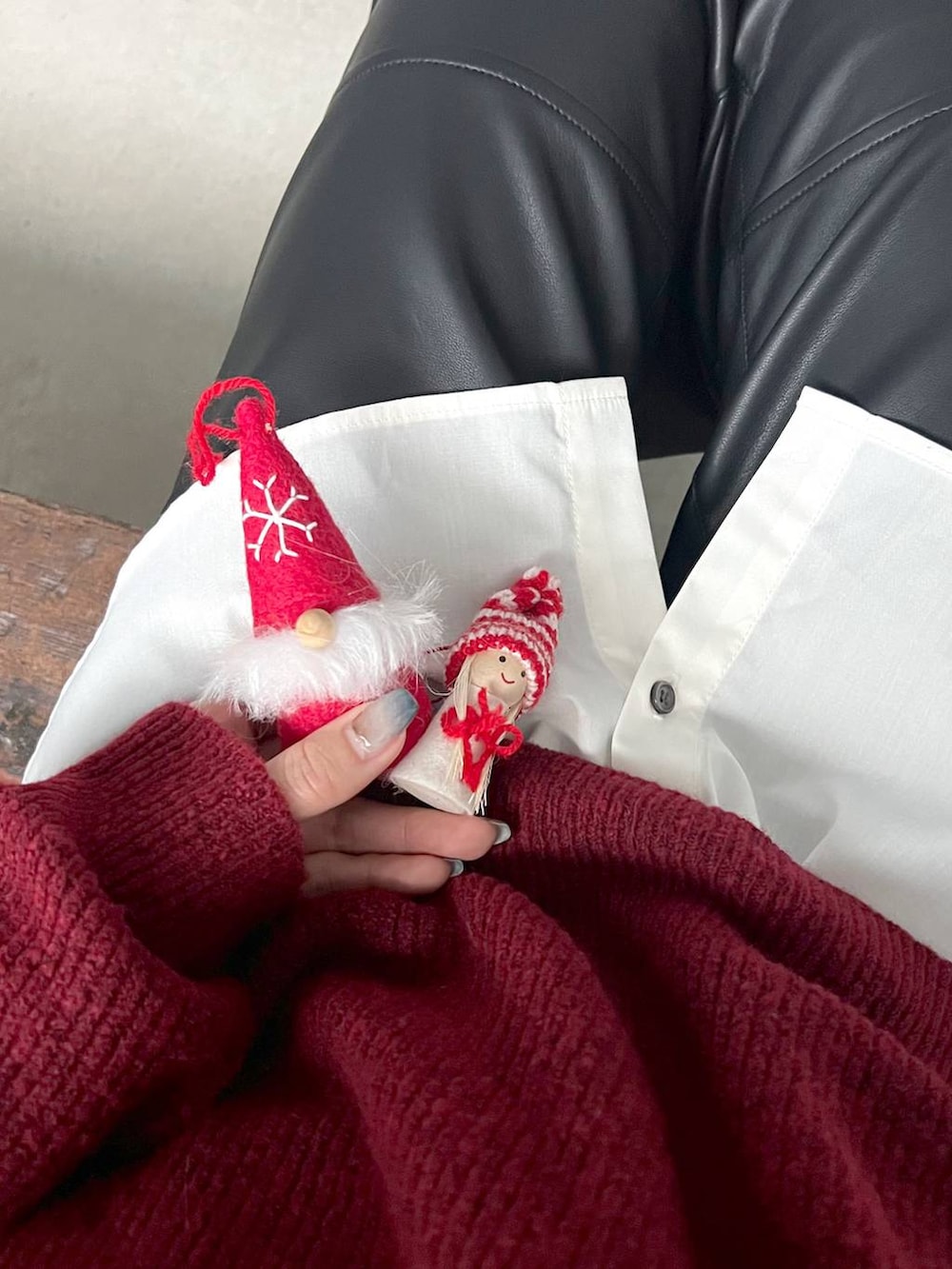 レッド系のニット/セーター、ブラック系のブーツ、ブラック系のスラックスを着用したレディースの冬コーディネートの5枚目の写真