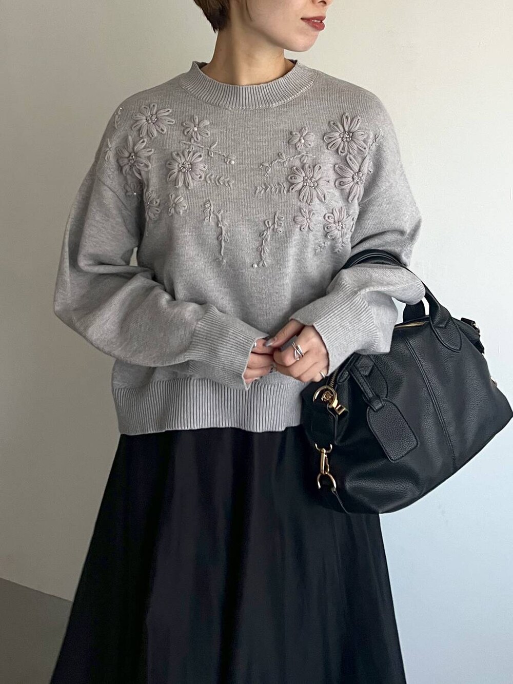 ブラック系のボストンバッグ、ブラック系のサンダル、グレー系のニット/セーターを着用したレディースの冬コーディネートの4枚目の写真