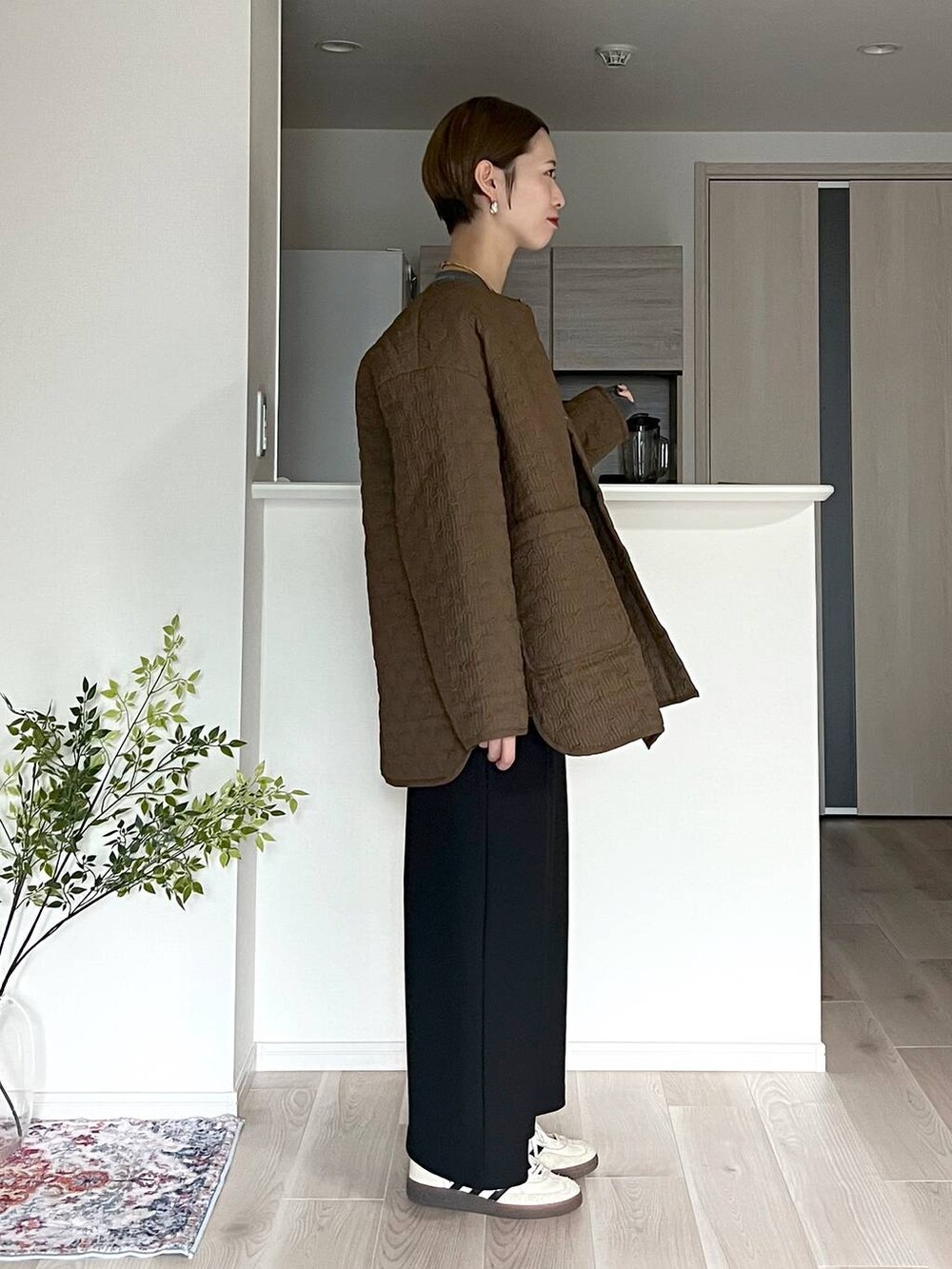 ブラウン系のボストンバッグ、ブラック系のスカート、ベージュ系のネックレスを着用したレディースの秋コーディネートの2枚目の写真