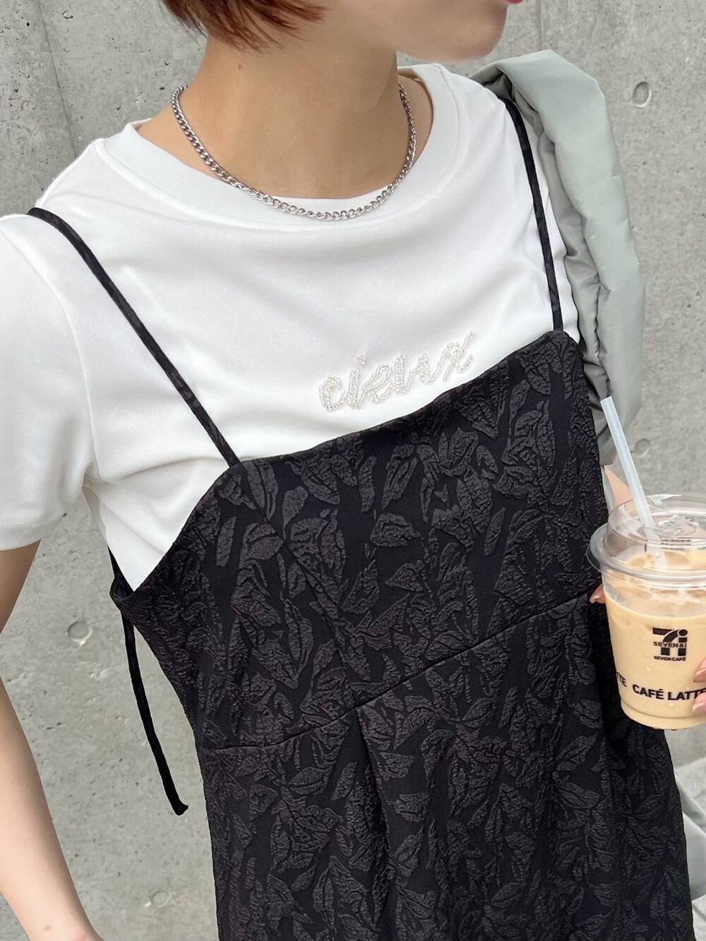 グリーン系のショルダーバッグ、ホワイト系のTシャツ/カットソー、ブラック系のサンダルを着用したレディースの夏コーディネートの3枚目の写真