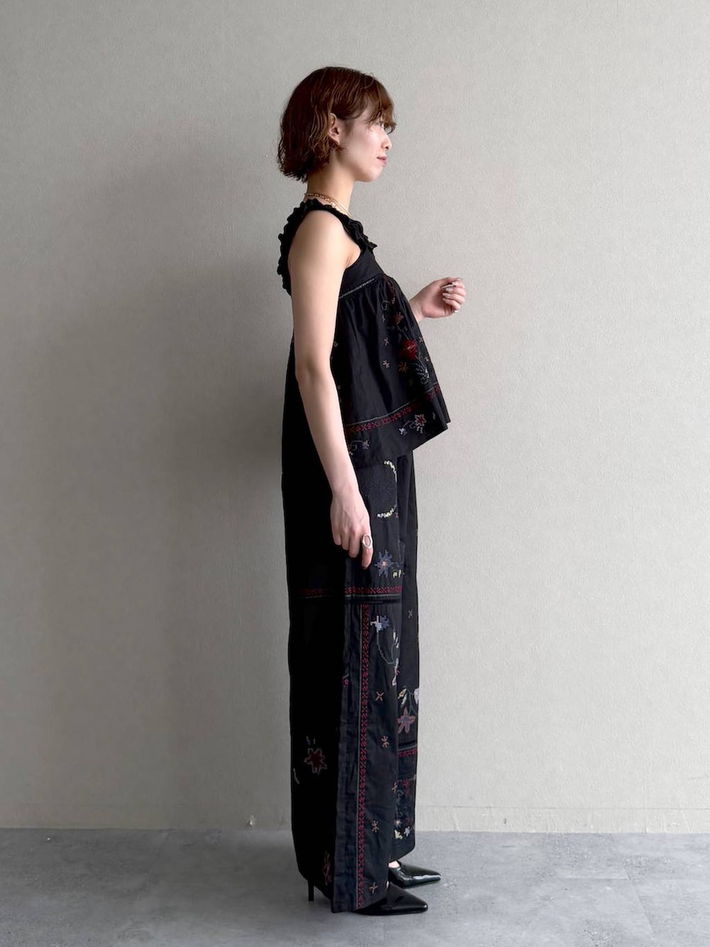 ブラック系のサンダル、ブラック系のその他パンツ、ブラック系のシャツ/ブラウスを着用したレディースの春コーディネートの2枚目の写真