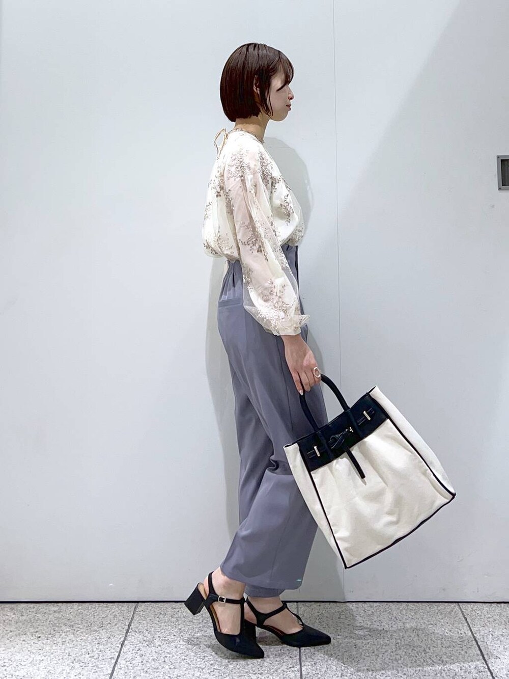 ブラック系のトートバッグ、ホワイト系のシャツ/ブラウス、ブラック系のパンプスを着用したレディースの冬コーディネートの5枚目の写真