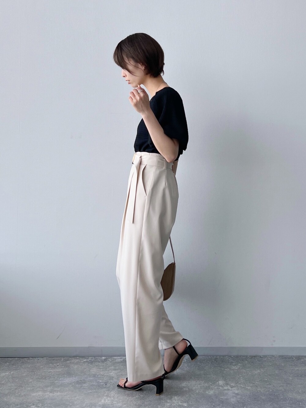 ブラック系のTシャツ/カットソー、ブラウン系のバッグ、ホワイト系のパンツを着用したレディースの夏コーディネートの2枚目の写真