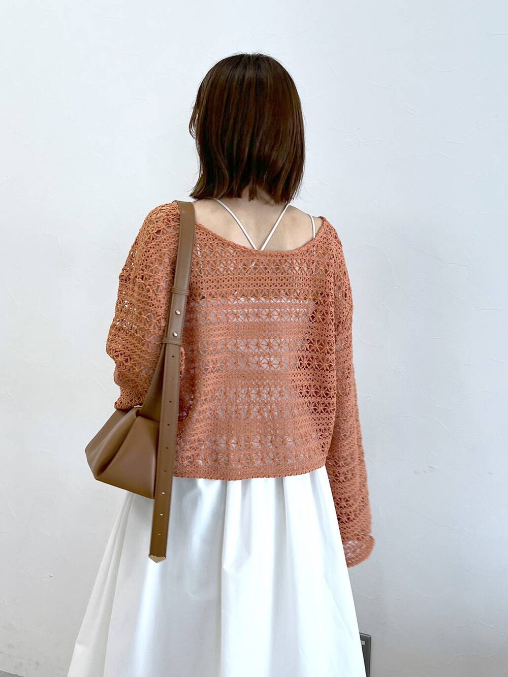 ホワイト系のサンダル、オレンジ系のカーディガン/ボレロ、ホワイト系のキャミソールを着用したレディースの春コーディネートの5枚目の写真