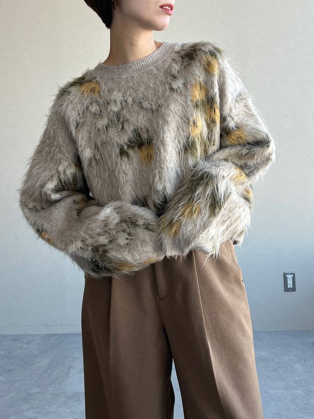 ベージュ系のニット/セーター、ブラック系のブーツ、ブラウン系のスラックスを着用したレディースの冬コーディネートの4枚目の写真