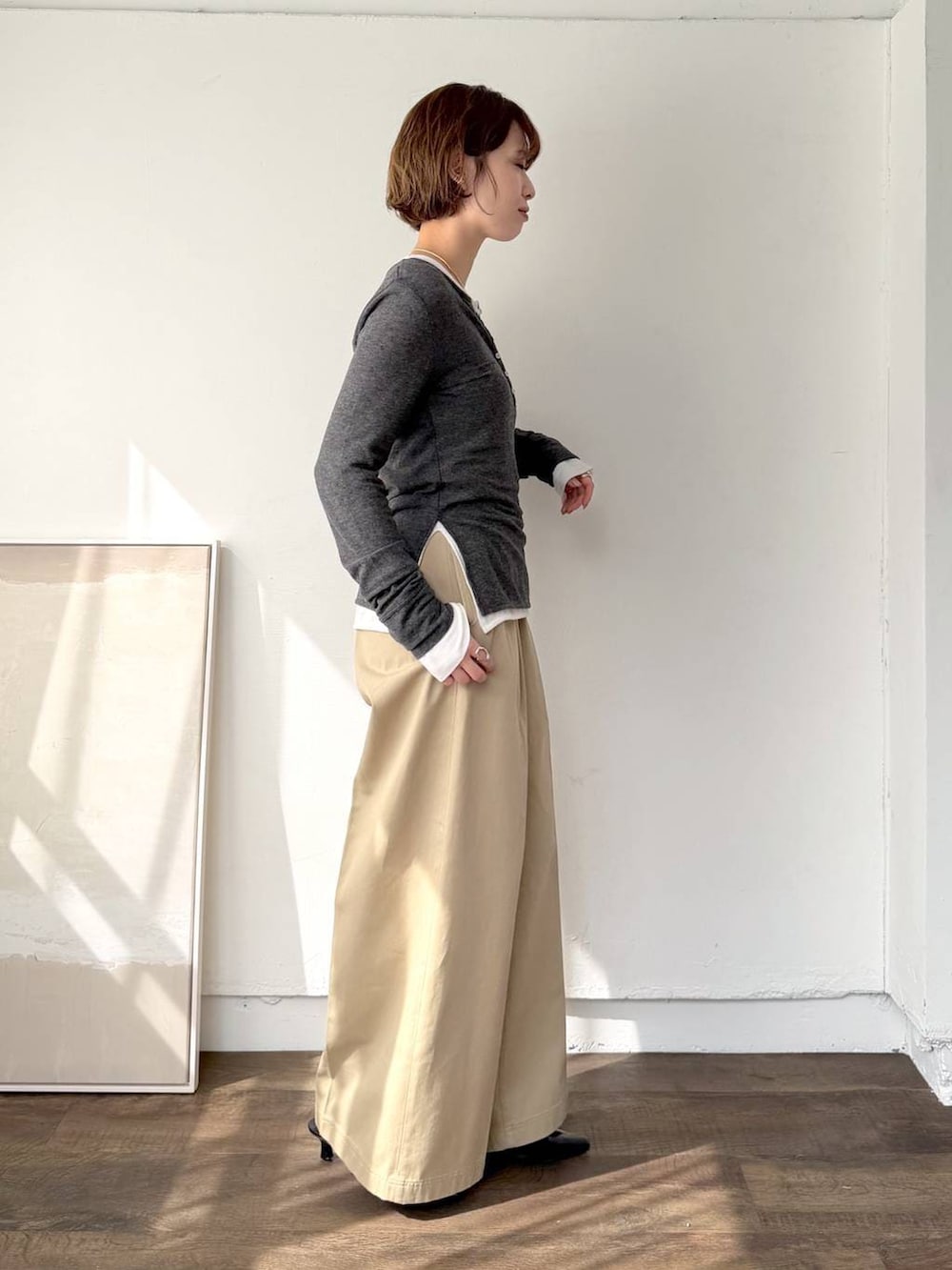 ブラック系のサンダル、ブラック系のショルダーバッグ、ベージュ系のチノパンツを着用したレディースの春コーディネートの2枚目の写真