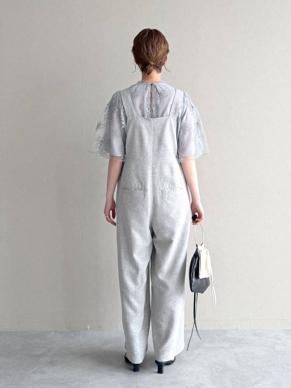 ブルー系のシャツ/ブラウス、ブラック系のハンドバッグ、ブラック系のサンダルを着用したレディースの春コーディネートの3枚目の写真