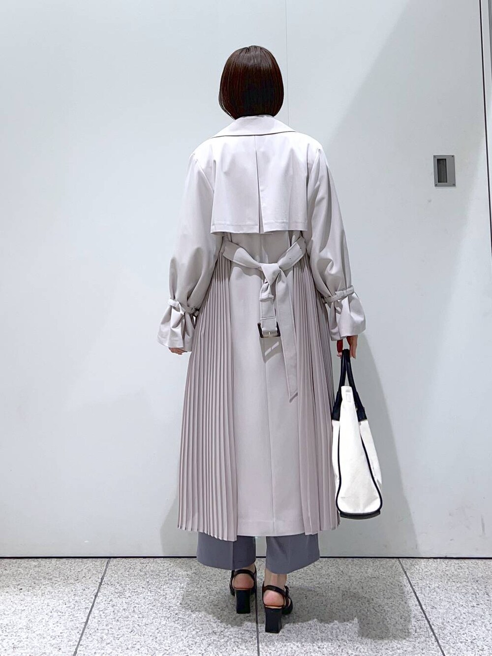 ブラック系のトートバッグ、ホワイト系のシャツ/ブラウス、ブラック系のパンプスを着用したレディースの冬コーディネートの3枚目の写真