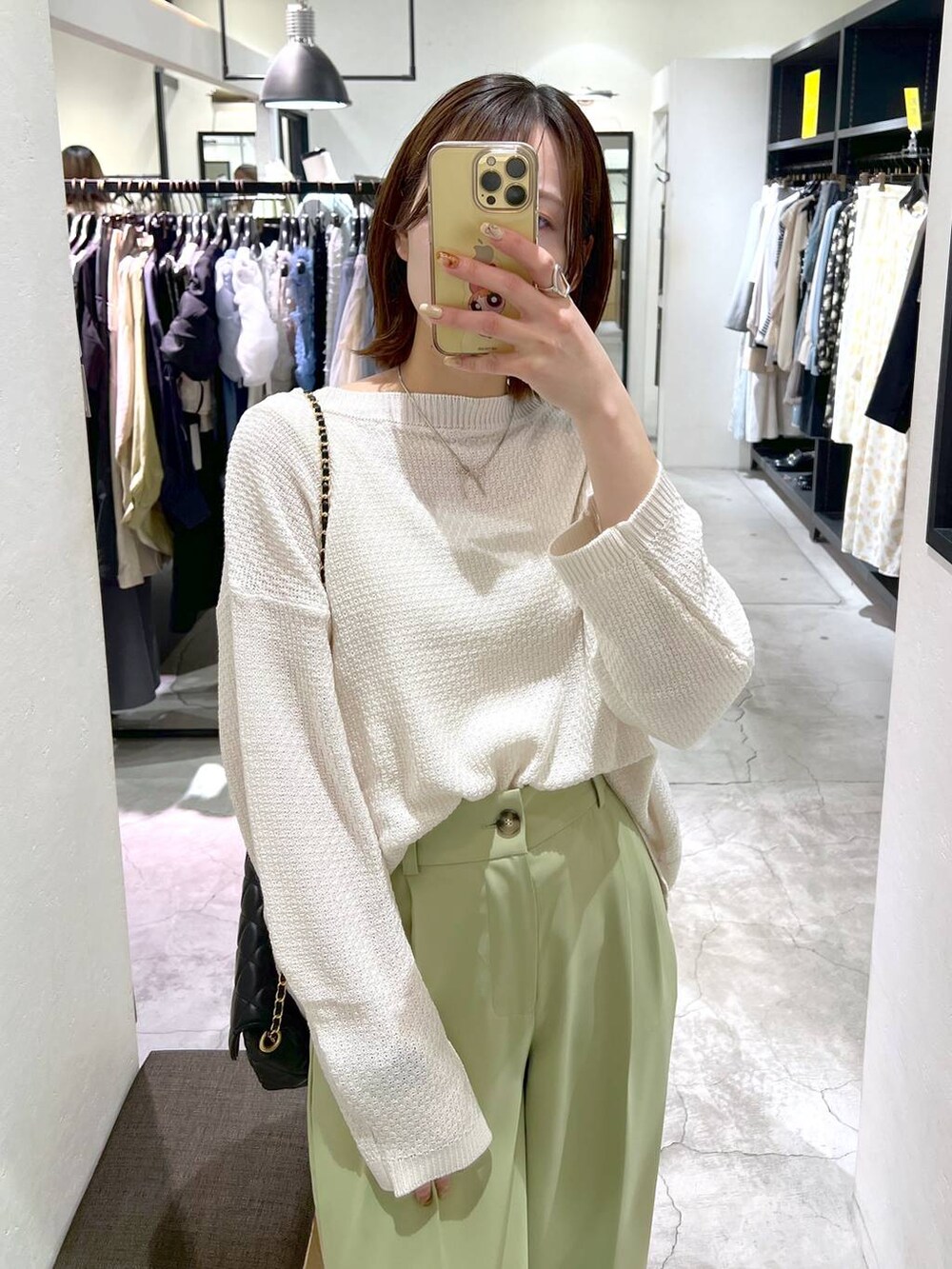 ホワイト系のTシャツ/カットソー、グリーン系のスラックス、ブラック系のショルダーバッグを着用したレディースの春コーディネートの5枚目の写真