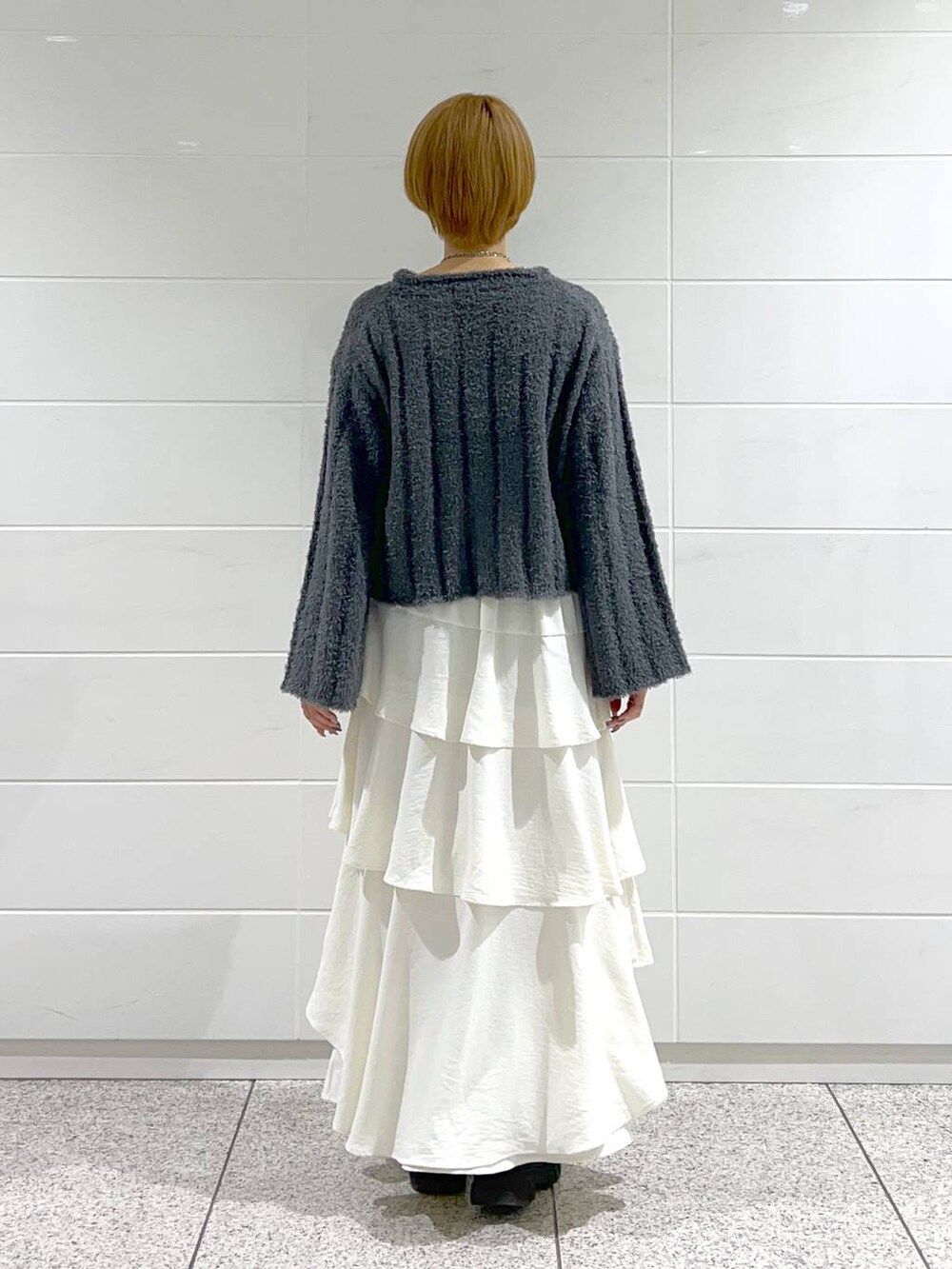 ブラック系のブーツ、ホワイト系のスカート、ブラック系のブルゾンを着用したレディースの冬コーディネートの6枚目の写真