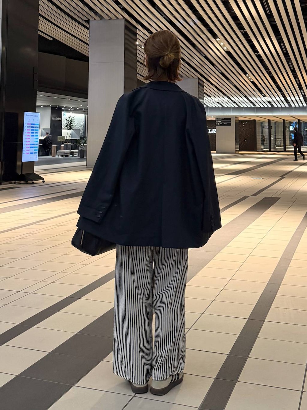 ブラック系のハンドバッグ、ブルー系のその他パンツ、ブルー系のテーラードジャケットを着用したレディースの春コーディネートの3枚目の写真