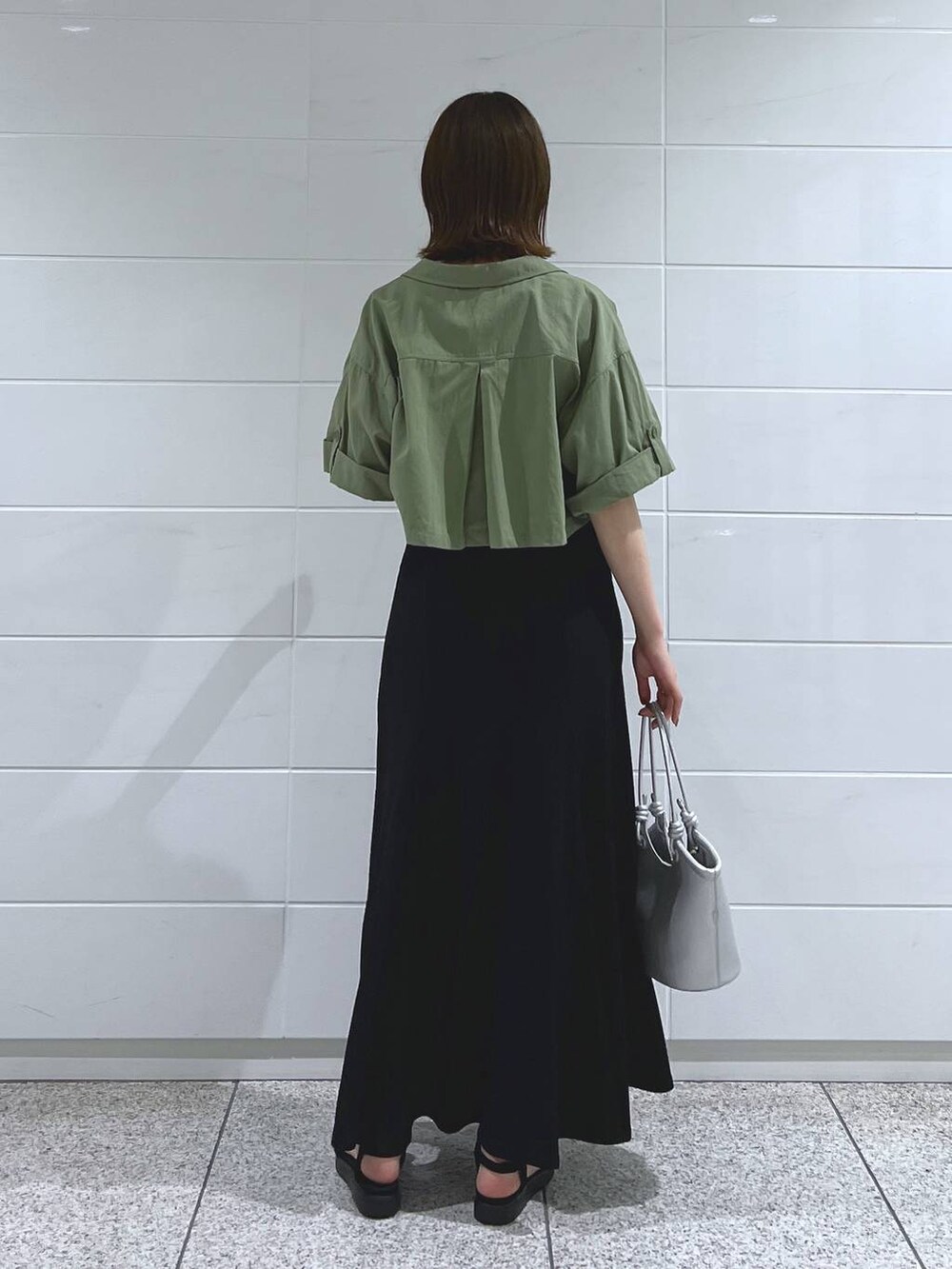 ブラック系のサンダル、シルバー系のハンドバッグ、グリーン系のミリタリージャケットを着用したレディースの夏コーディネートの4枚目の写真