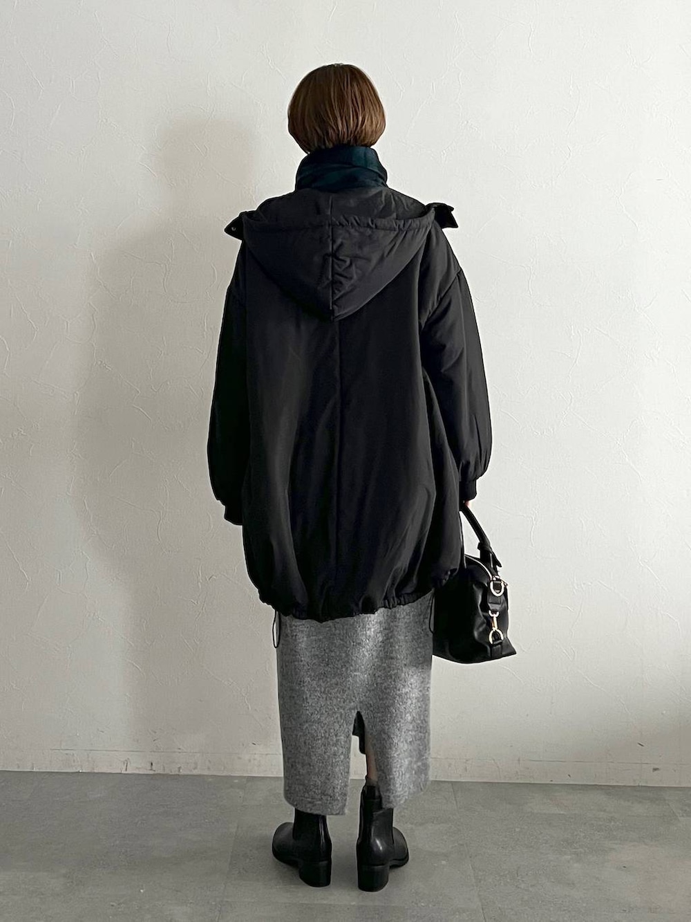 ブラック系のボストンバッグ、ブラック系のブーツ、ブラック系のブルゾンを着用したレディースの冬コーディネートの3枚目の写真