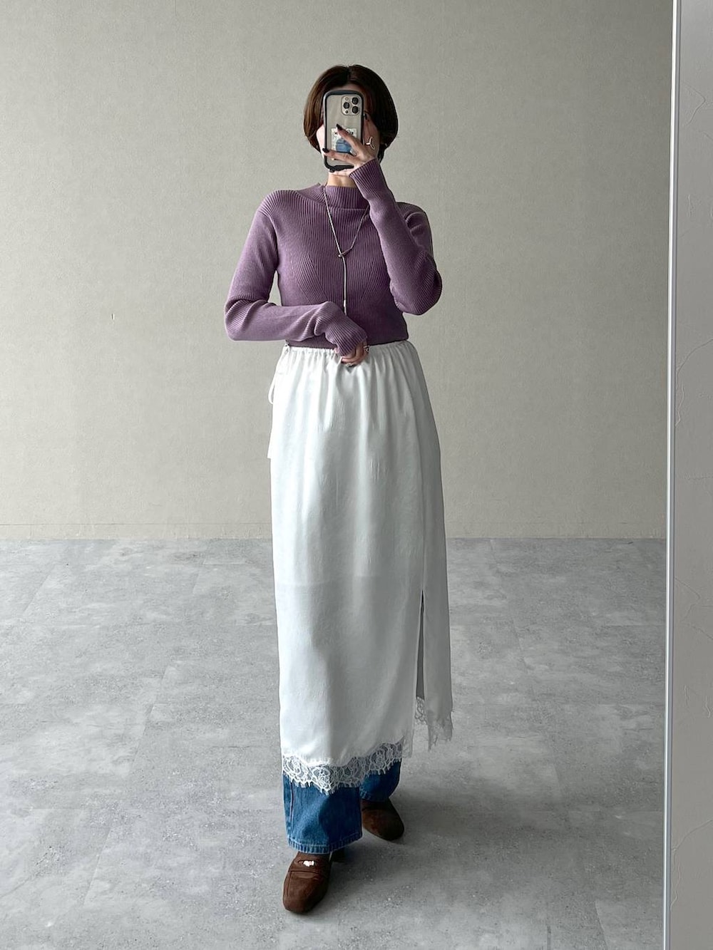 パープル系のニット/セーター、ブルー系のデニムパンツ、ブラウン系のローファーを着用したレディースの秋コーディネートの4枚目の写真