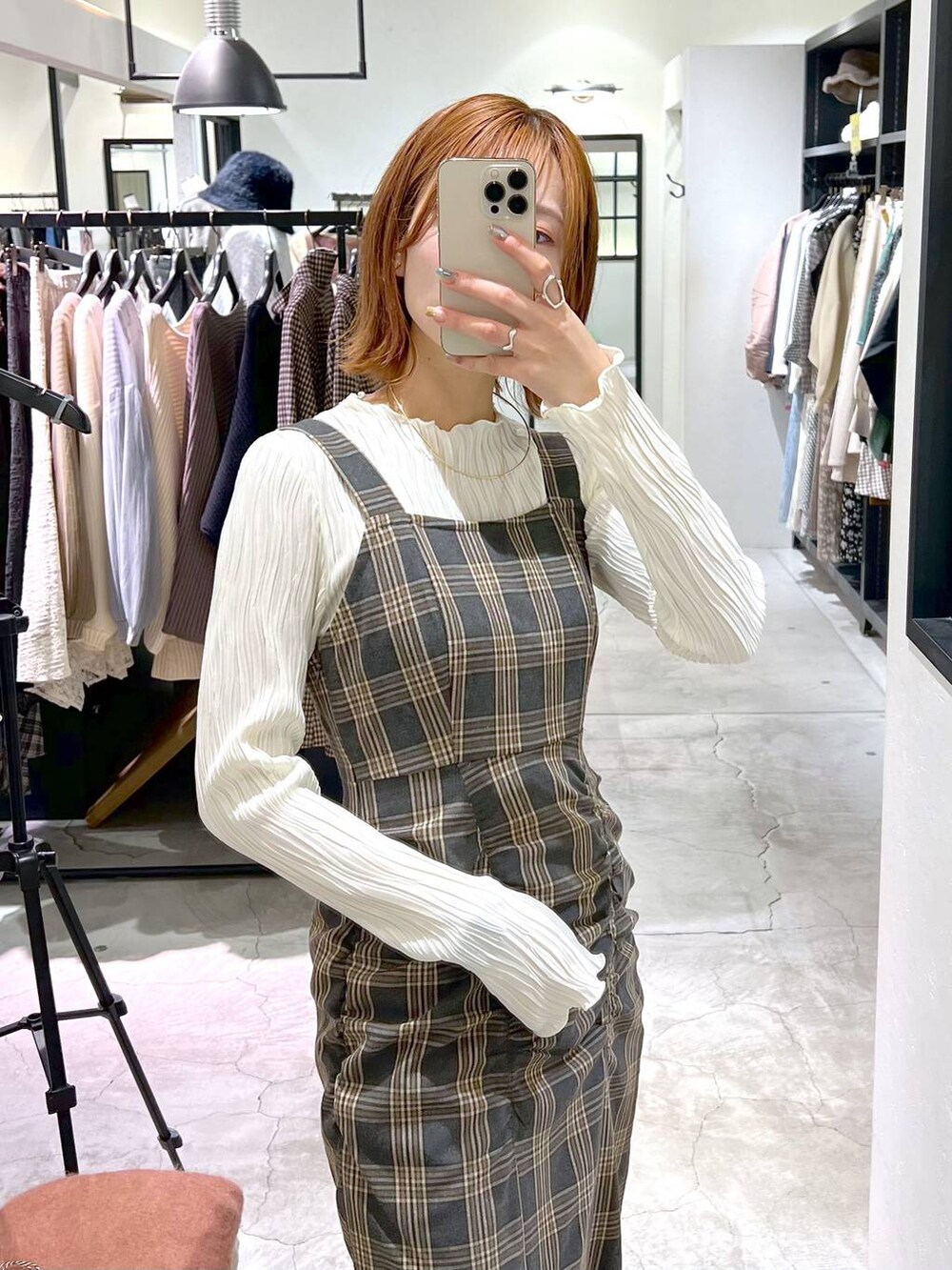 ブラウン系のハンドバッグ、ブラック系のブーツ、グレー系のジャンパースカートを着用したレディースの秋コーディネートの2枚目の写真