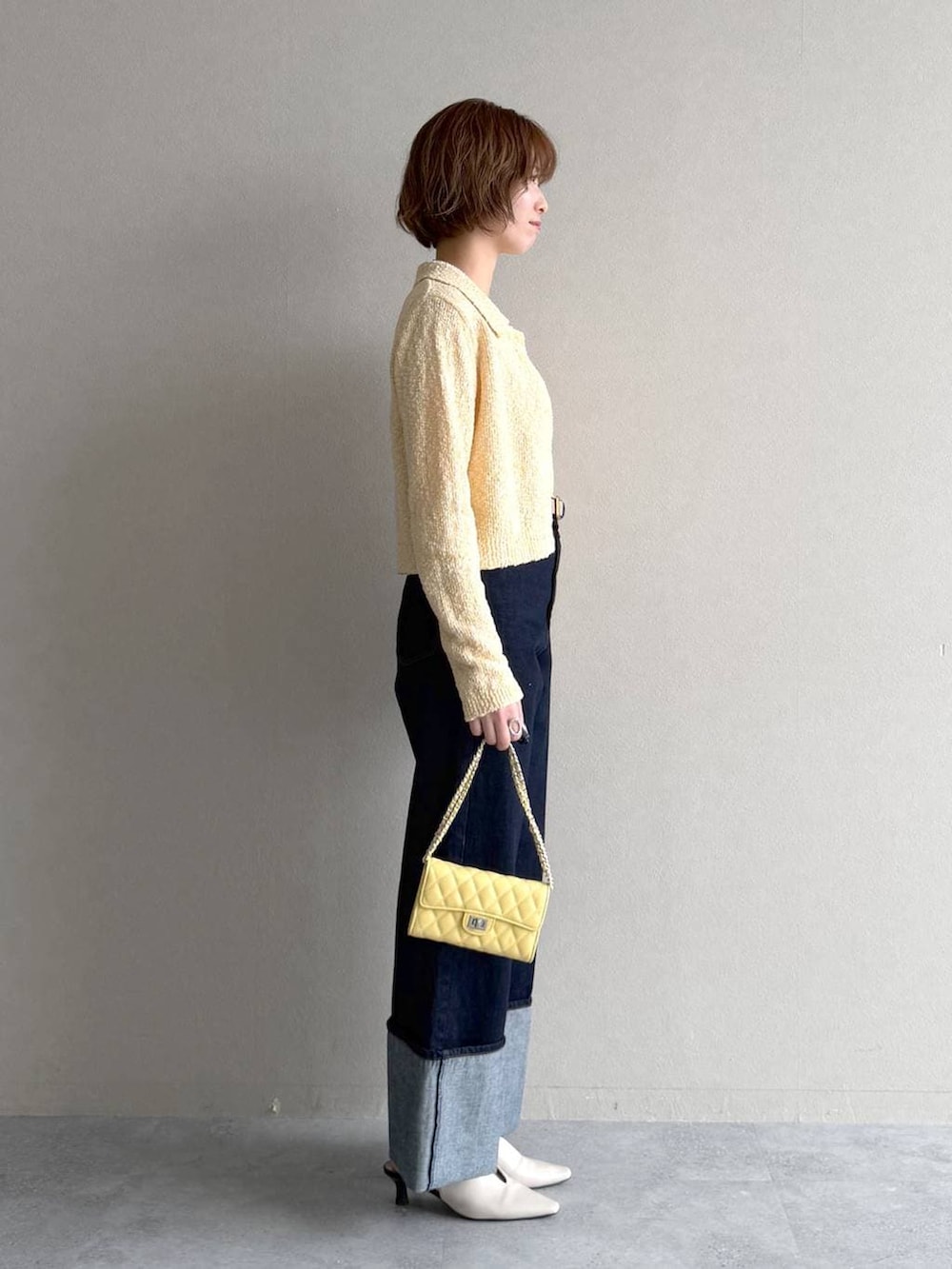 ホワイト系のサンダル、ブラウン系のブルゾン、イエロー系のカーディガン/ボレロを着用したレディースの春コーディネートの6枚目の写真