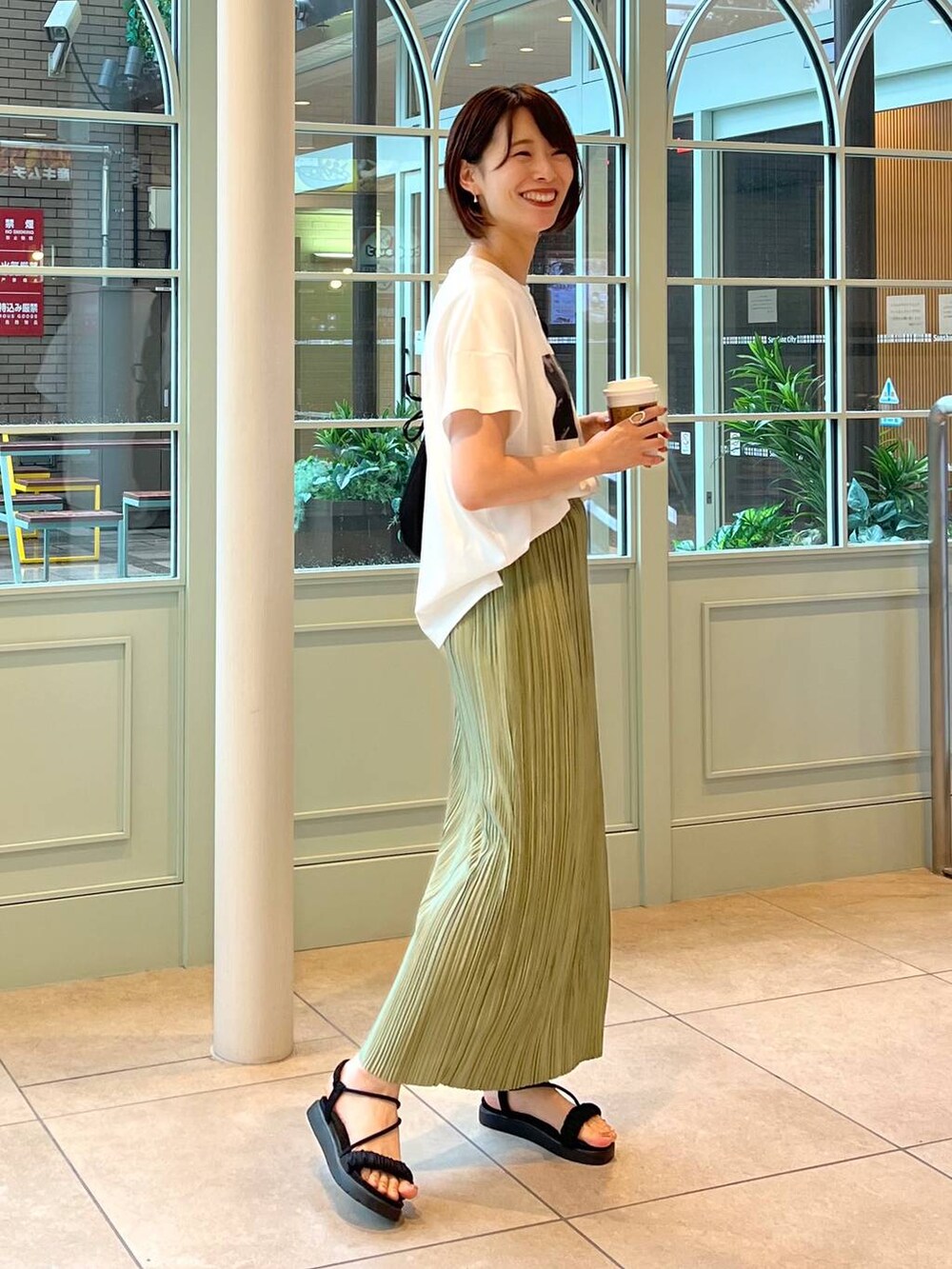 ブラック系のサンダル、ブラック系のショルダーバッグ、ホワイト系のTシャツ/カットソーを着用したレディースの夏コーディネートの2枚目の写真