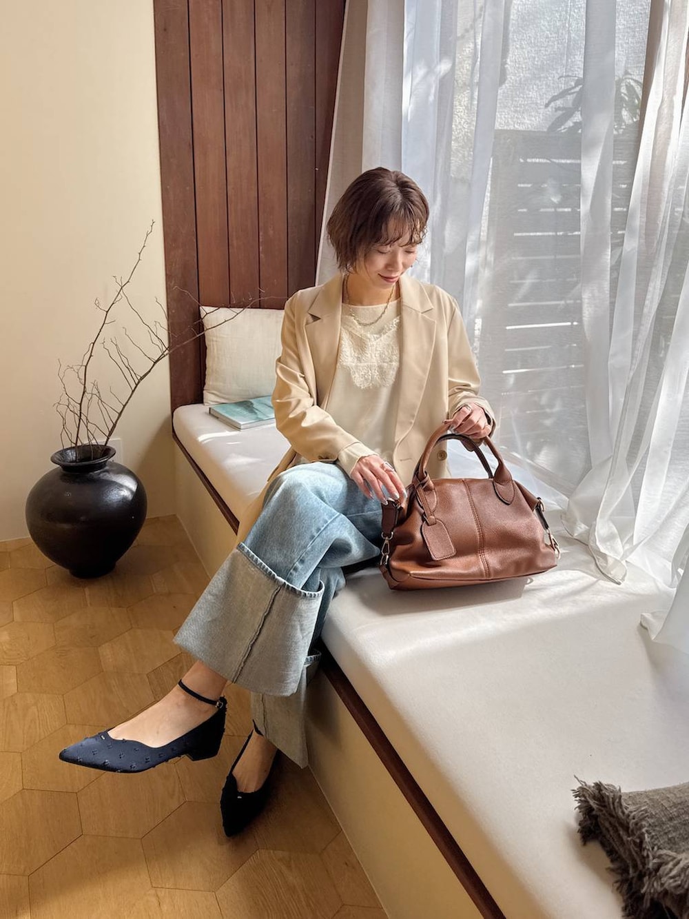 ブラウン系のボストンバッグ、ブルー系のパンプス、ホワイト系のキャミソールを着用したレディースの冬コーディネートの8枚目の写真