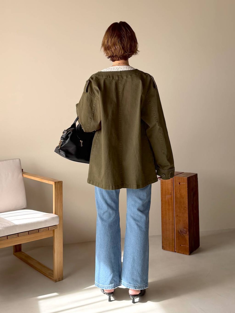 ブラック系のボストンバッグ、ブルー系のデニムパンツ、ブラック系のサンダルを着用したレディースの冬コーディネートの3枚目の写真