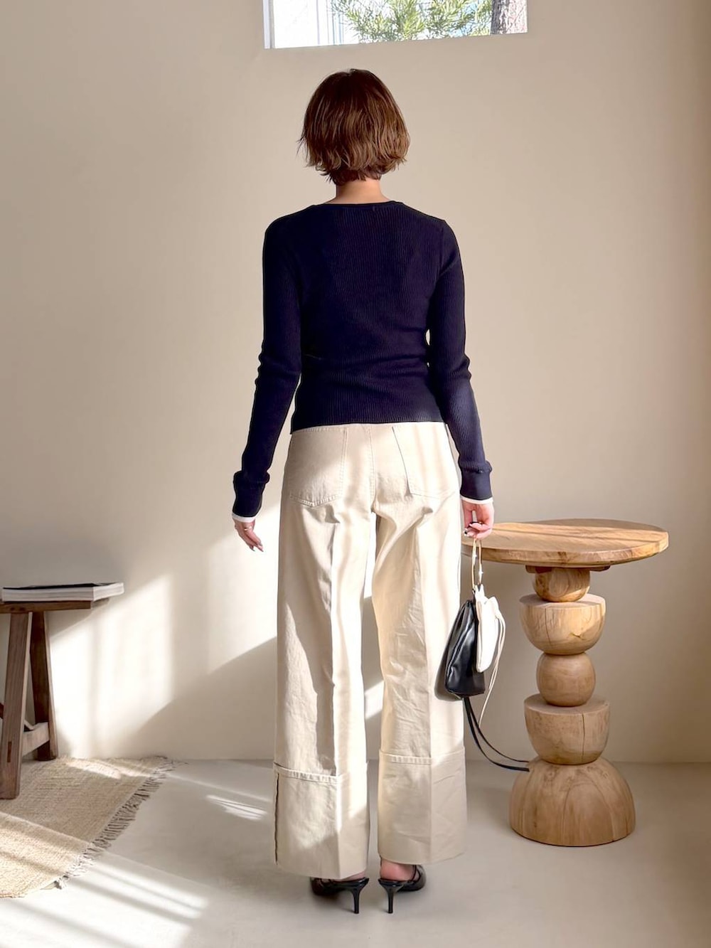 ブラック系のサンダル、ブルー系のニット/セーター、ブラック系のハンドバッグを着用したレディースの冬コーディネートの3枚目の写真