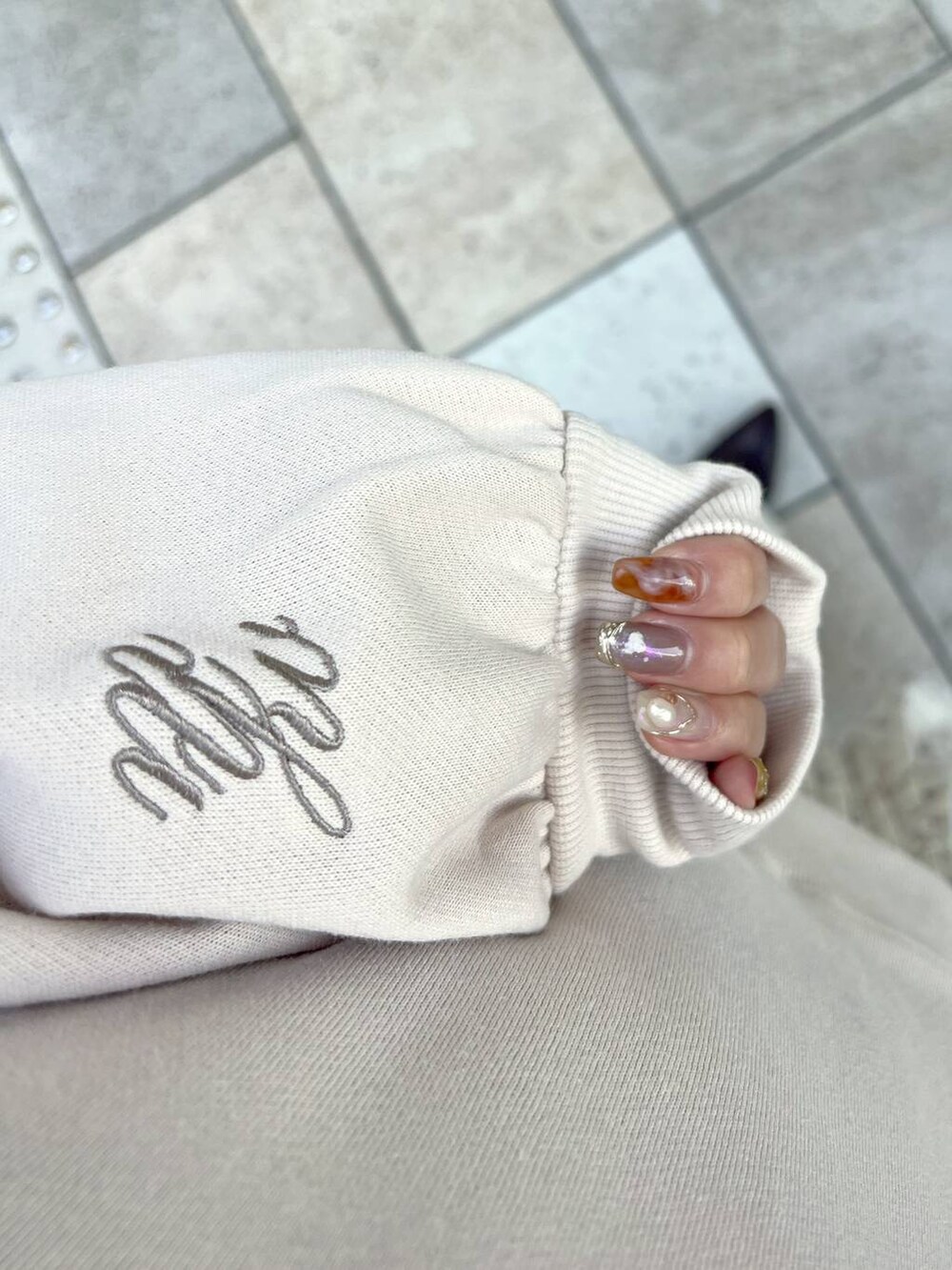 ホワイト系のショルダーバッグ、ブラウン系のブーツ、ベージュ系のスカートを着用したレディースの冬コーディネートの5枚目の写真