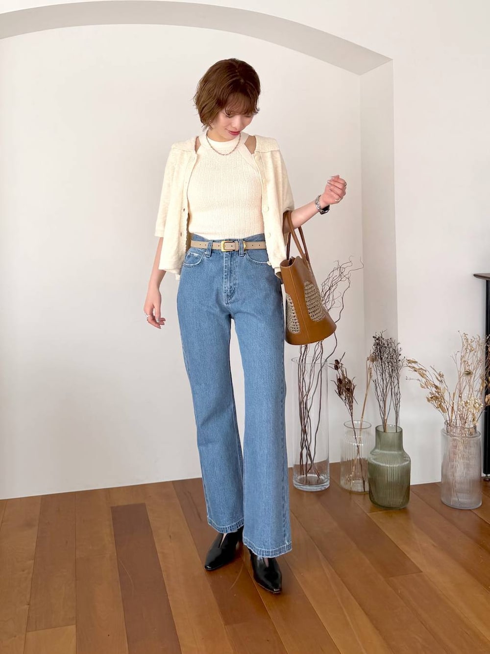 ブラウン系のトートバッグ、ブルー系のデニムパンツ、ブラック系のサンダルを着用したレディースの春コーディネートの7枚目の写真