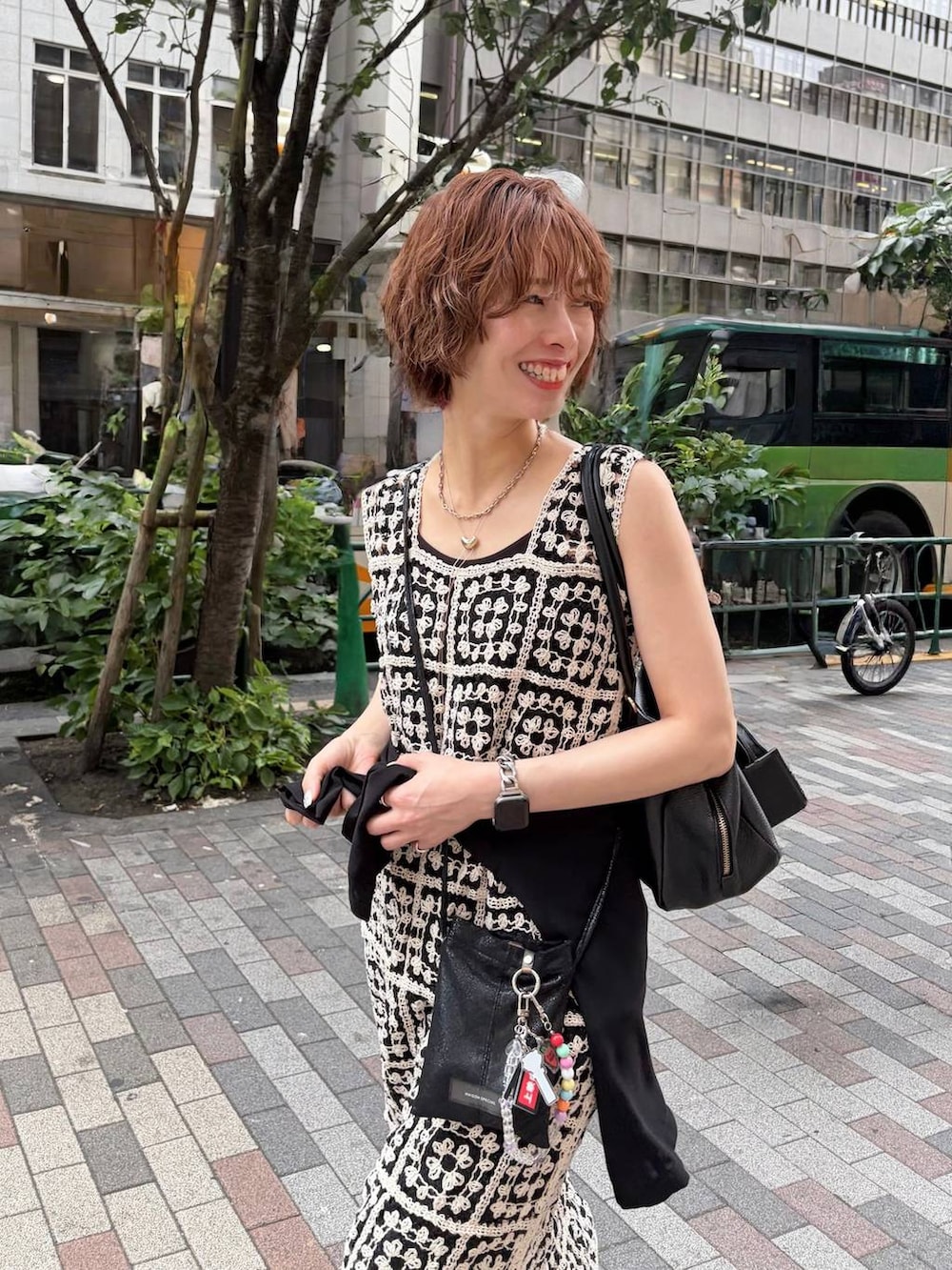 その他のワンピース、ブラック系のハンドバッグ、ブルー系のデニムパンツを着用したレディースの夏コーディネートの6枚目の写真