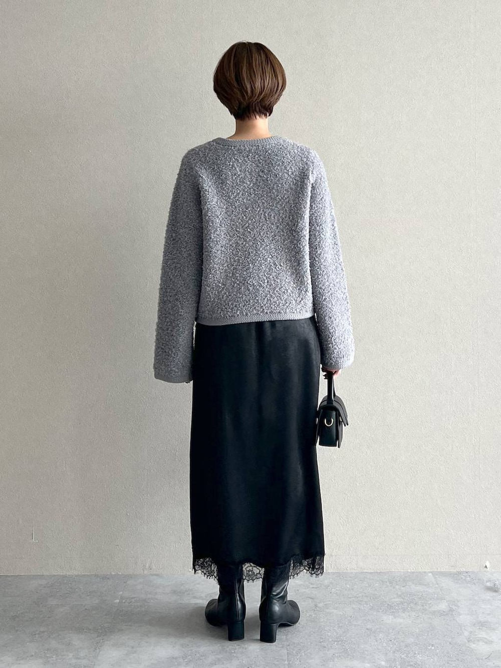 グレー系のカーディガン/ボレロ、ブラック系のブーツ、ブラック系のスカートを着用したレディースの秋コーディネートの3枚目の写真