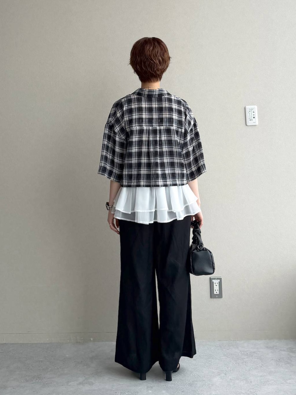 ブラック系のシャツ/ブラウス、ブルー系のニット/セーター、ブラック系のサンダルを着用したレディースの夏コーディネートの3枚目の写真