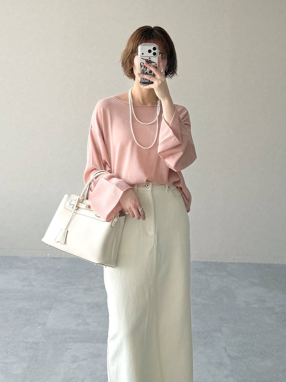 ピンク系のニット/セーター、ブラウン系のサンダル、ホワイト系のスカートを着用したレディースの春コーディネートの4枚目の写真