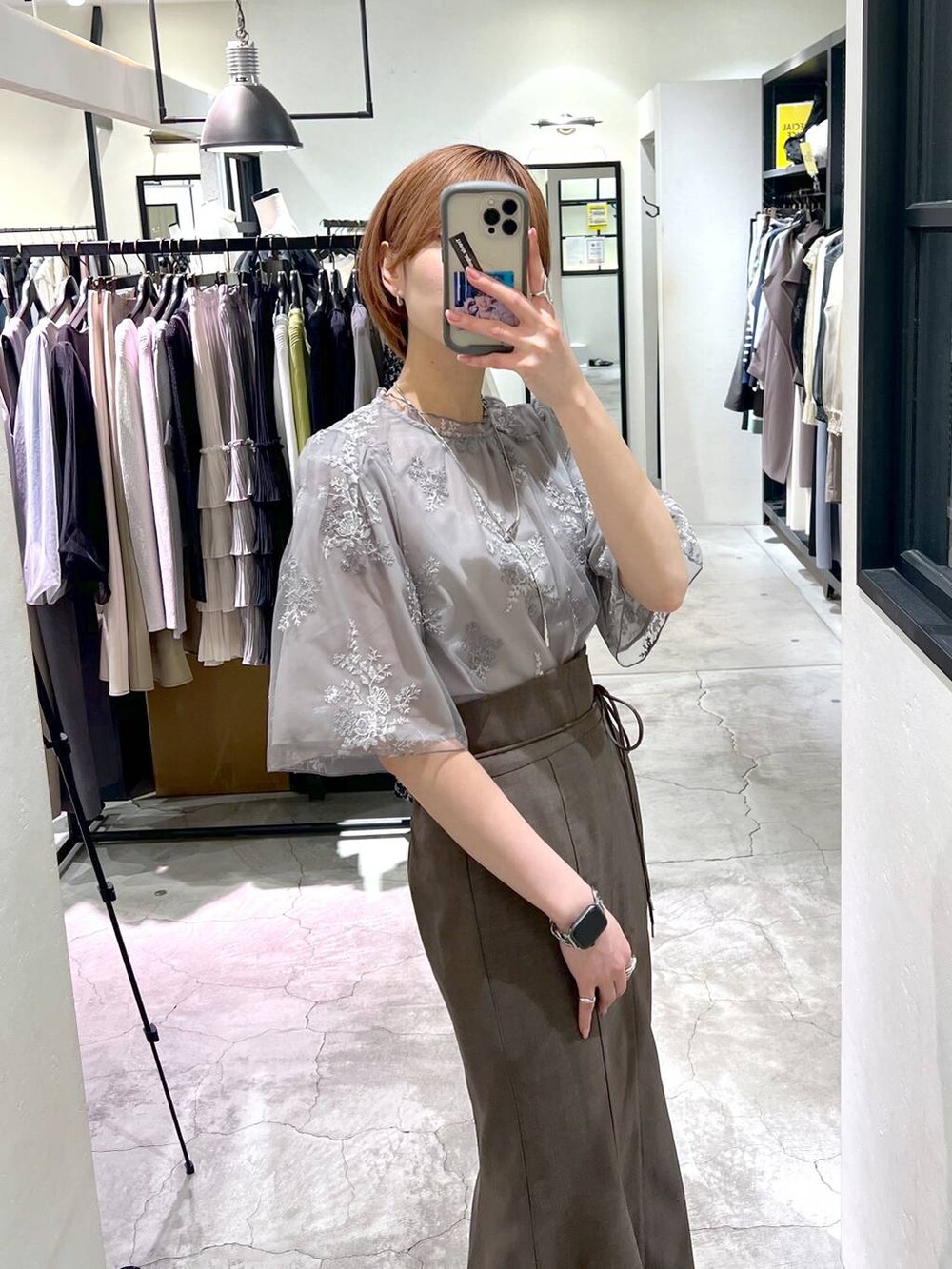 ベージュ系のショルダーバッグ、ブラック系のパンプス、グレー系のスカートを着用したレディースの春コーディネートの4枚目の写真