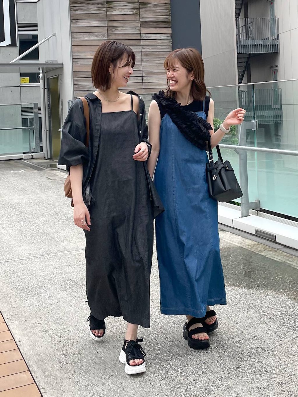 ブラック系のサンダル、ブラウン系のショルダーバッグ、ブラック系のワンピースを着用したレディースの春コーディネートの6枚目の写真