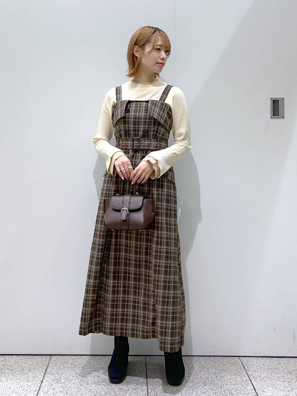 ブラック系のその他アウター、ブラウン系のハンドバッグ、ブラック系のブーツを着用したレディースの秋コーディネートの4枚目の写真