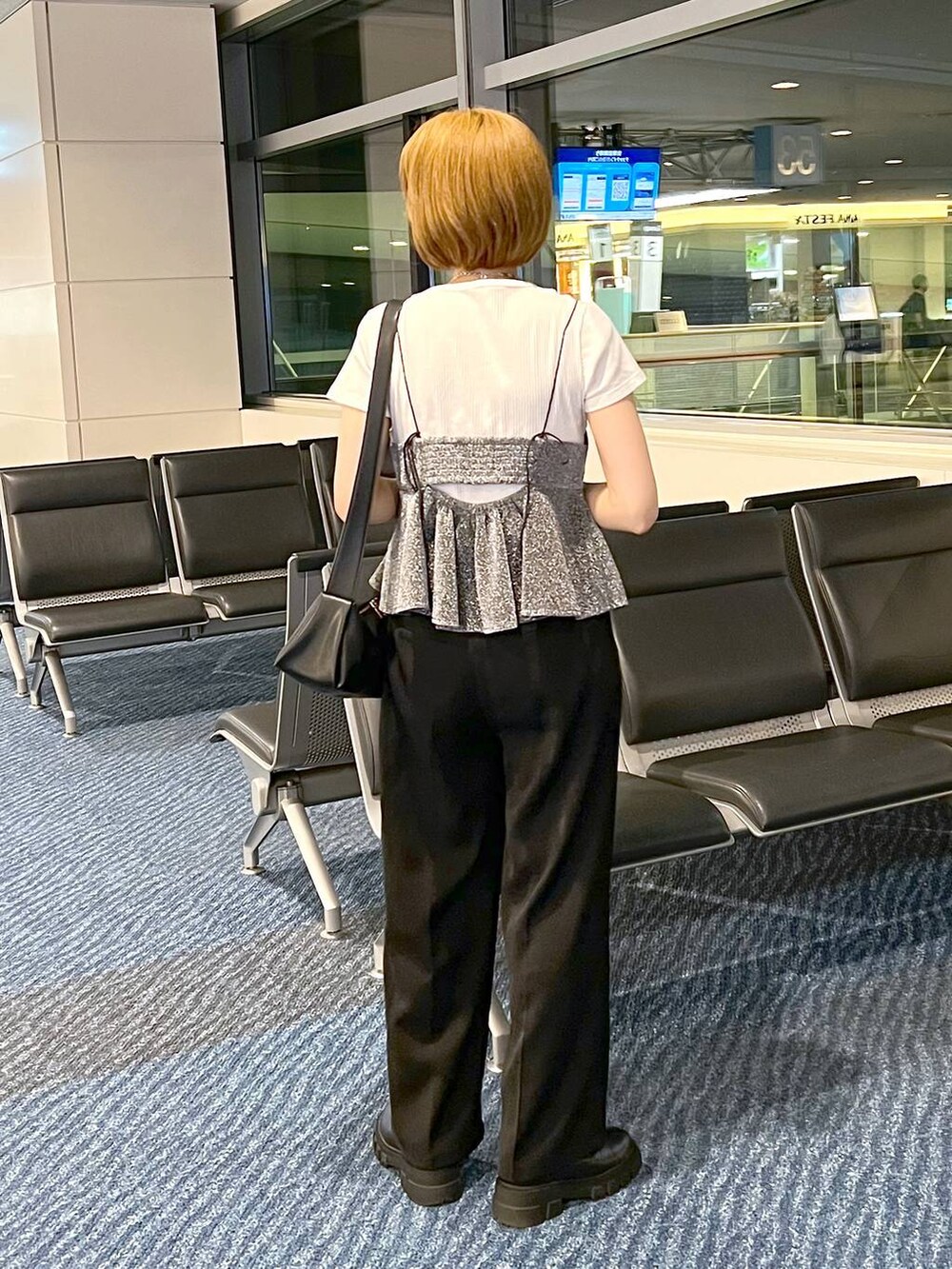 ブラック系のショルダーバッグ、グレー系のキャミソール、ブラック系のスラックスを着用したレディースの秋コーディネートの3枚目の写真