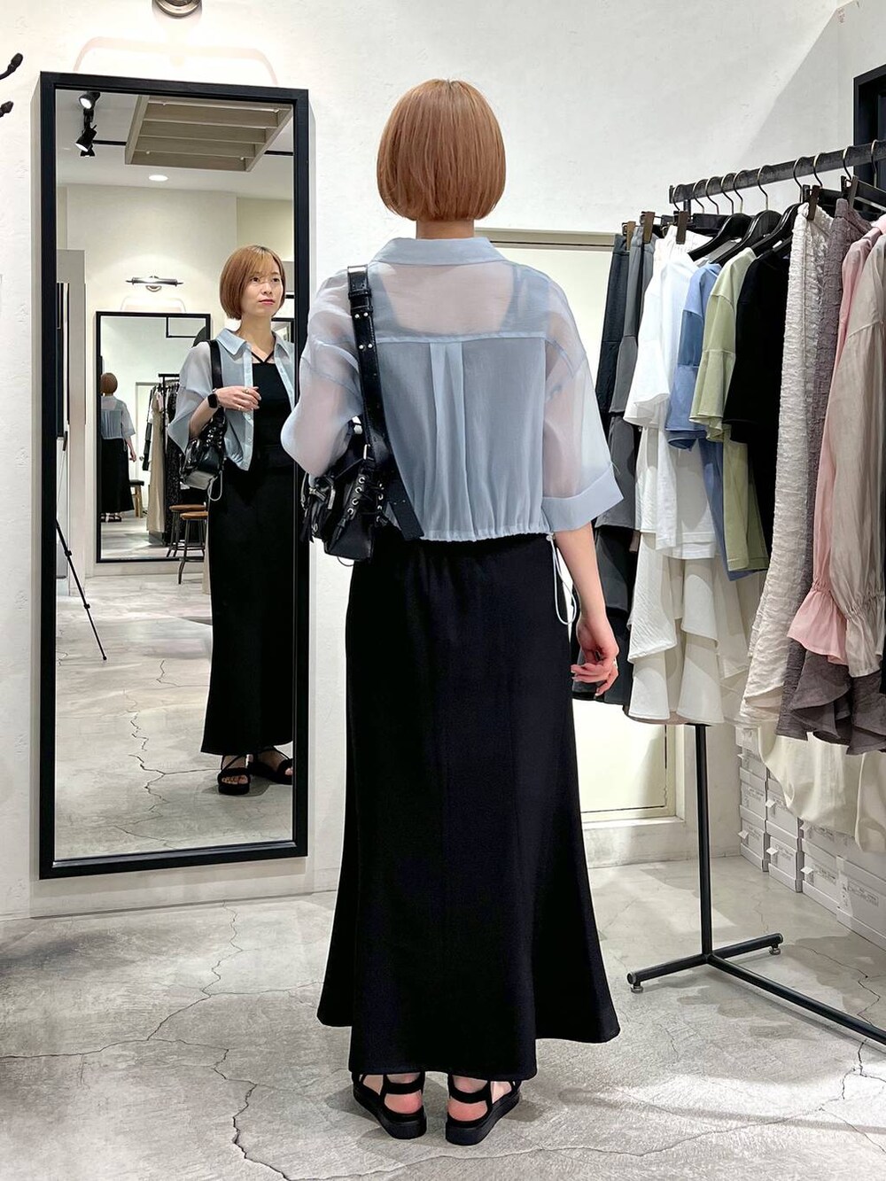 ブラック系のカーディガン/ボレロ、ブラック系のサンダル、ブラック系のスカートを着用したレディースの春コーディネートの3枚目の写真