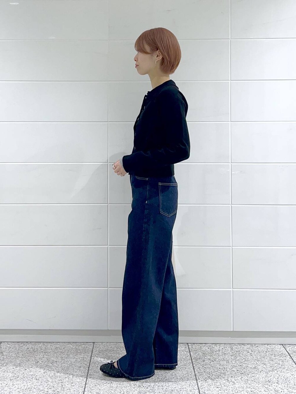 ブルー系のデニムパンツ、ベージュ系のショルダーバッグ、ブラック系のバレエシューズを着用したレディースの春コーディネートの2枚目の写真