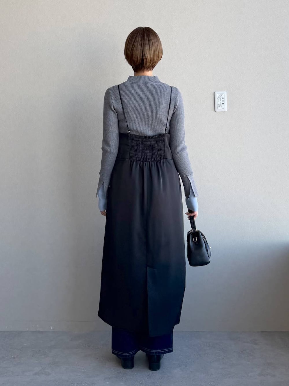 ブラック系のローファー、ブラック系のショルダーバッグ、グレー系のニット/セーターを着用したレディースの冬コーディネートの3枚目の写真