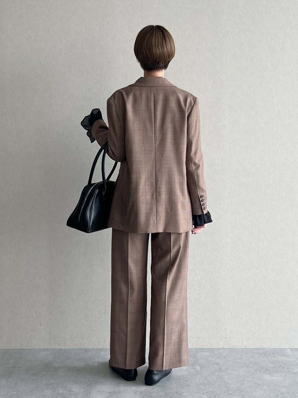 ベージュ系のスラックス、ベージュ系のテーラードジャケット、ブラック系のシャツ/ブラウスを着用したレディースの秋コーディネートの3枚目の写真