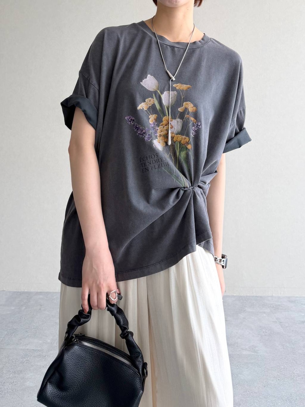 ブラック系のショルダーバッグ、グレー系のTシャツ/カットソー、ブラック系のサンダルを着用したレディースの夏コーディネートの4枚目の写真