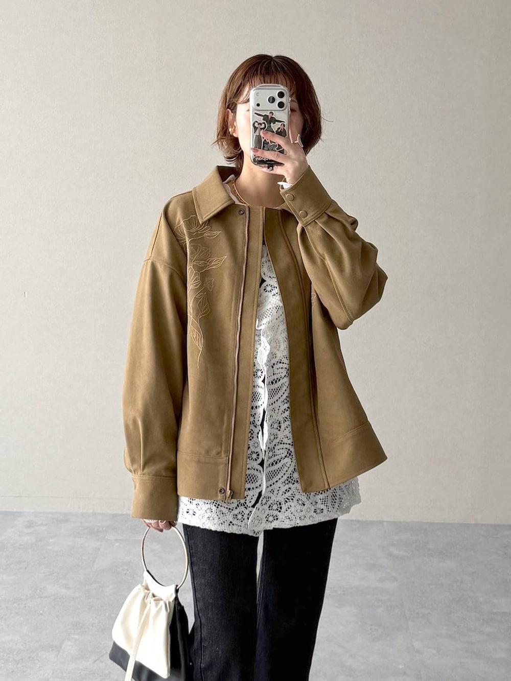 ブラック系のデニムパンツ、ブラック系のサンダル、ブラウン系のブルゾンを着用したレディースの冬コーディネートの4枚目の写真